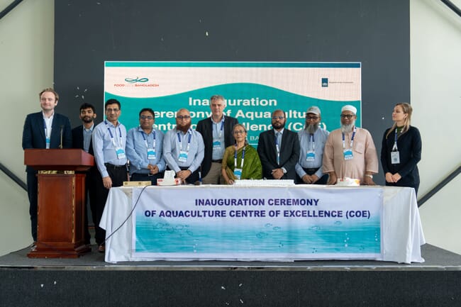A group of people celebrating the opening of a new aquaculture hub in Bangladesh.