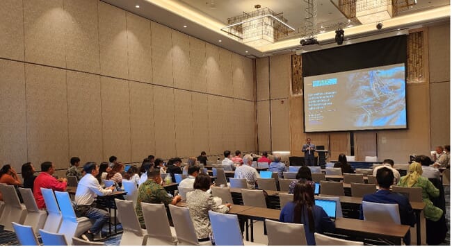 Presenter speaking to an audience at the 11th International Fisheries Symposium.