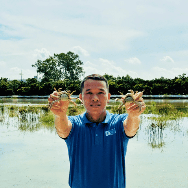 Tran Van Van holding mitten crab.