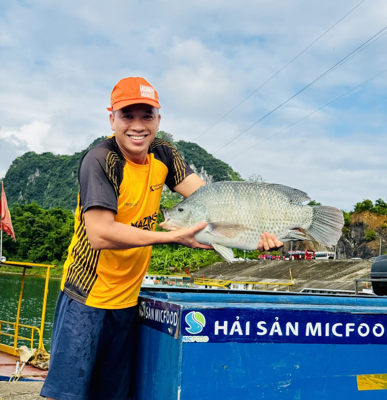 A man holding a tilapia.