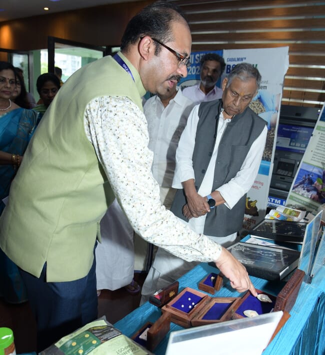 An Indian agriculture minister looking at cultured pearls in a research centre.