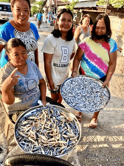 Three Filipino fisherfolk with fish.