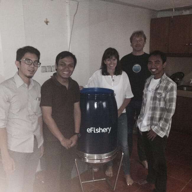 Five people smiling at the camera in an office