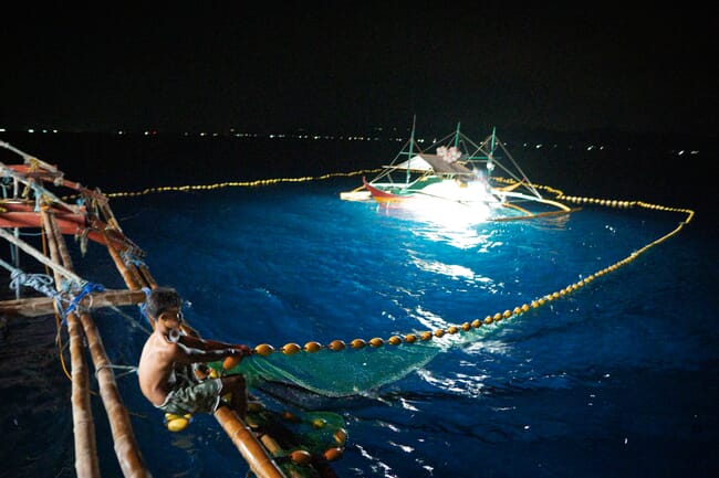 man pulling in a fishing net