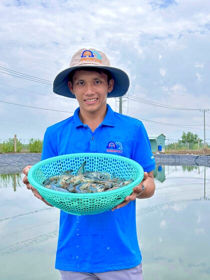 Man holding basket of harvested shrimp