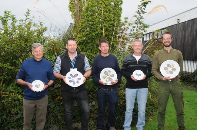 Five people holding up ceremonial plates.