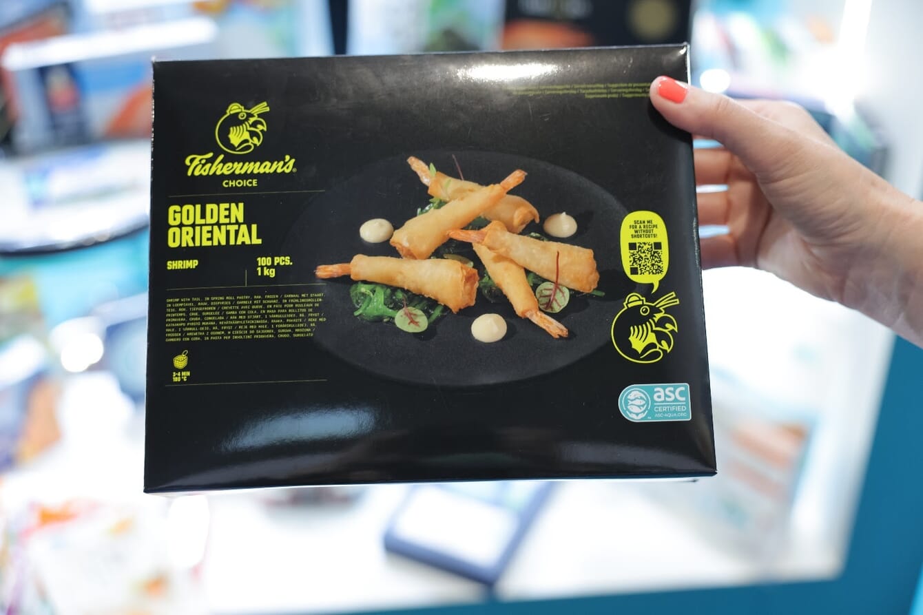 A person holding a box of fried shrimp.