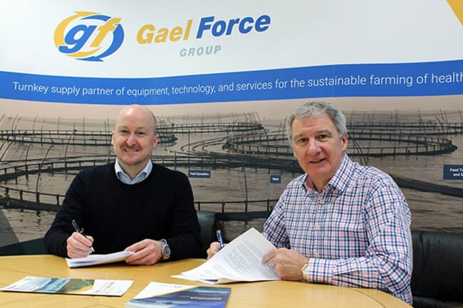 Two men at a table signing documents