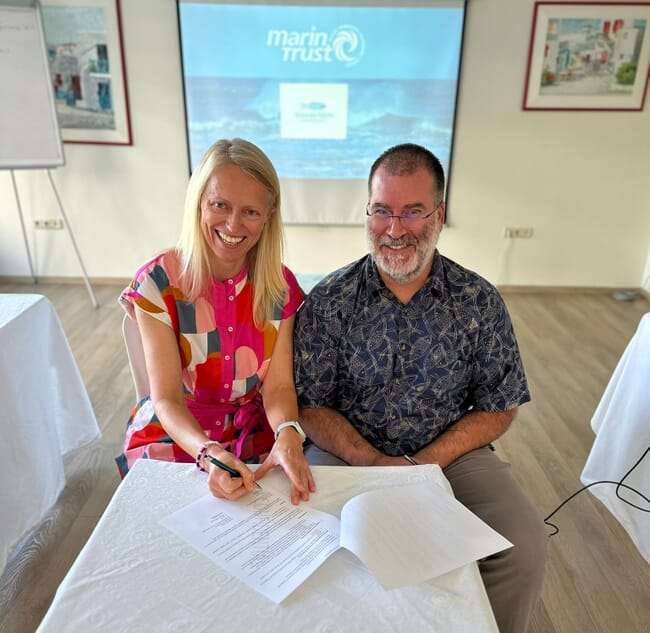 Two people signing a Memorandum of Understanding.