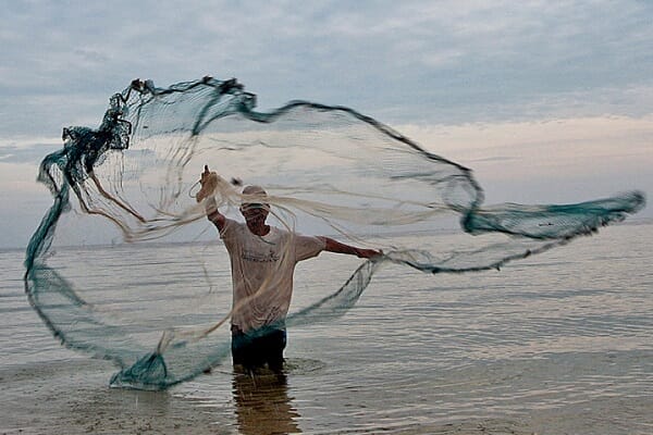person throwing a net into the water