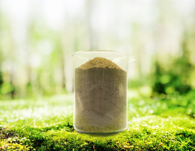 A beaker filled with grey powder.