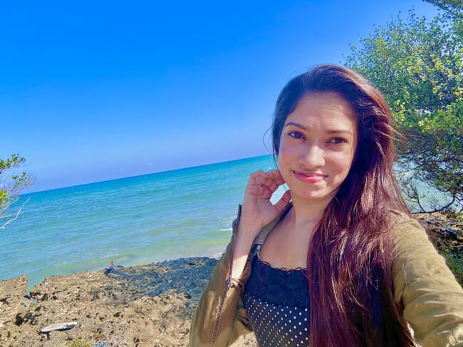 A woman standing beside the sea.