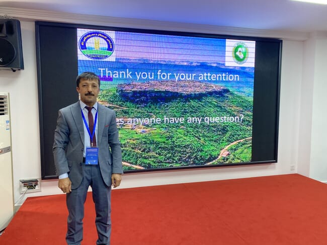 A man standing in front of a presentation on a screen.