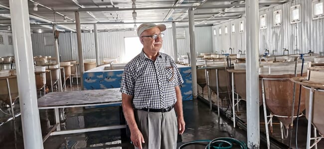 A man standing in a fish hatchery.