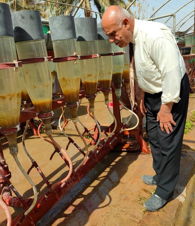 A man examining some liquid-filled containers