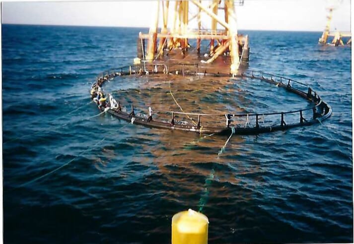 oil rig with ocean net pen attached