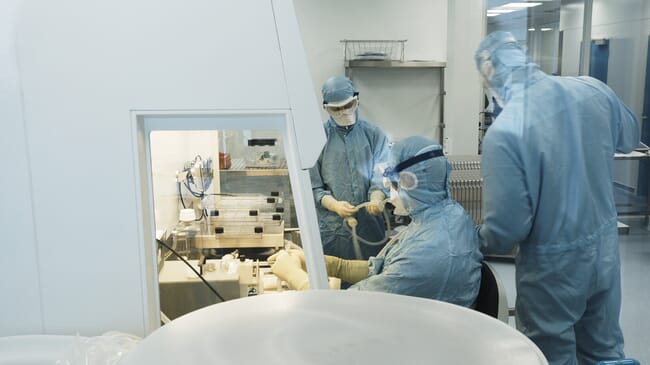 People in protective suits in a laboratory.