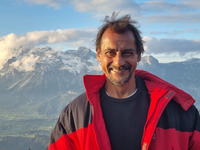 a man standing in front of a snowy mountain