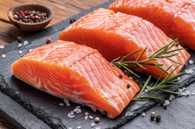 salmon fillets on a black slate