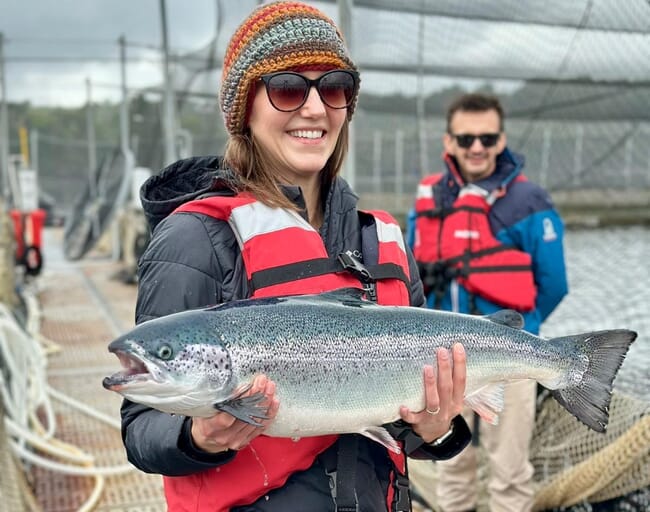 Woman holding salmon.