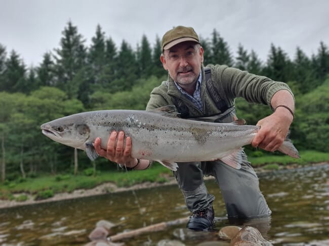 A man holding a large salmon.