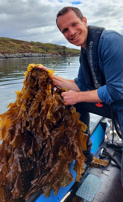 Person on a boat holding seaweed