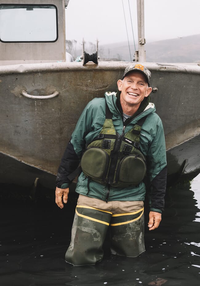 A man standing in front of a boat.