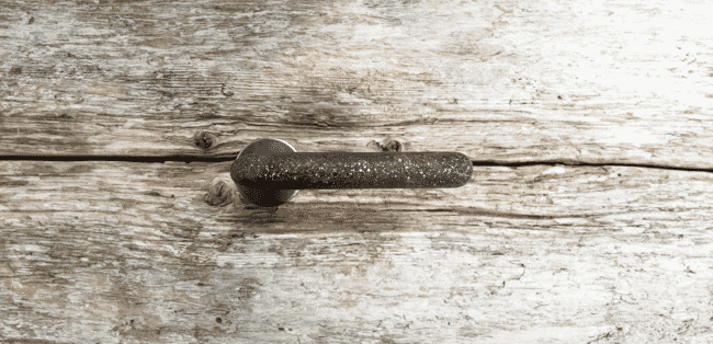 A contemporary handle on an old wooden door.