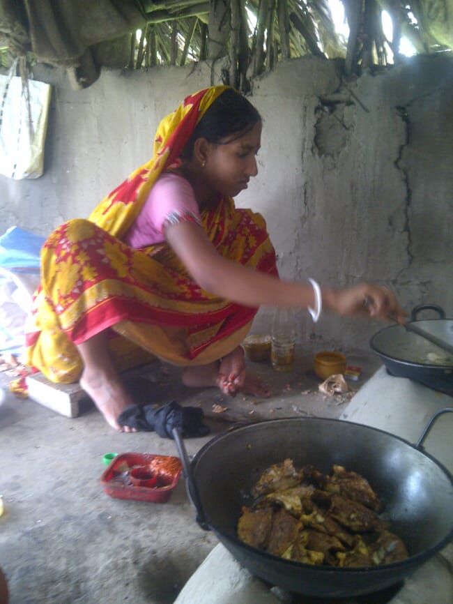uma mulher cozinhando peixe