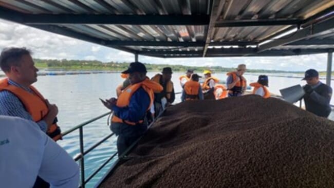 group standing on a barge filled with aquafeed