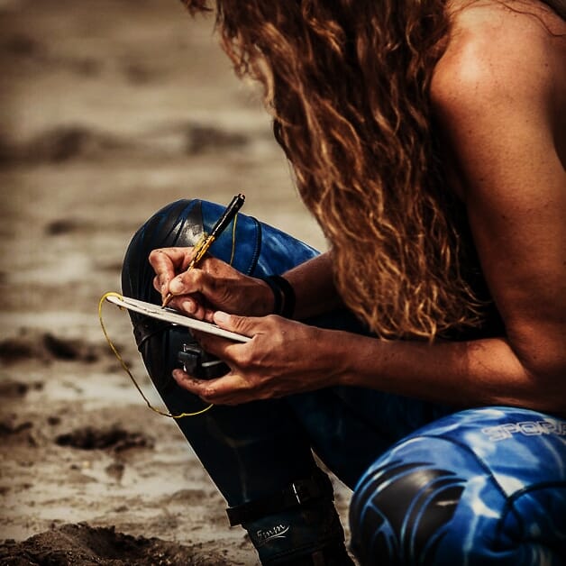 woman taking notes on the shore