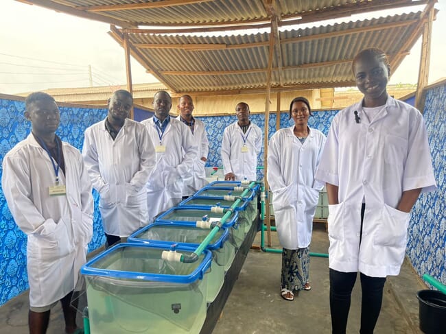 group of people standing in a fish hatchery