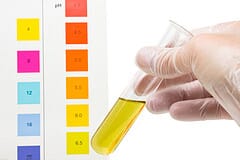 Person holding a test tube containing yellow liquid